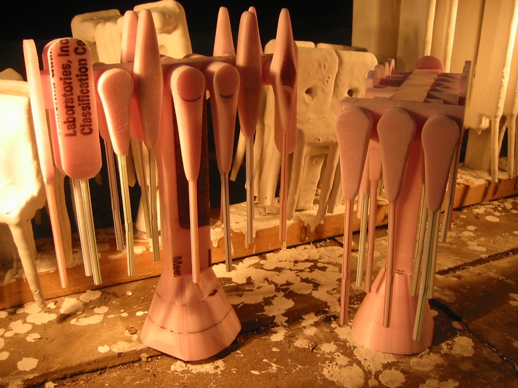 Multiple small foam parts each with a drinking straw attached for a vent and then all attached to a shared runner and spur.