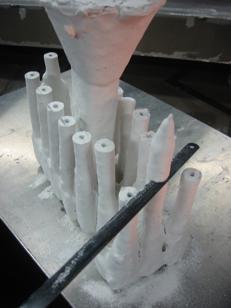 Trimming off the drinking straws. The parts have been coated with multiple layers of sheetrock mud.