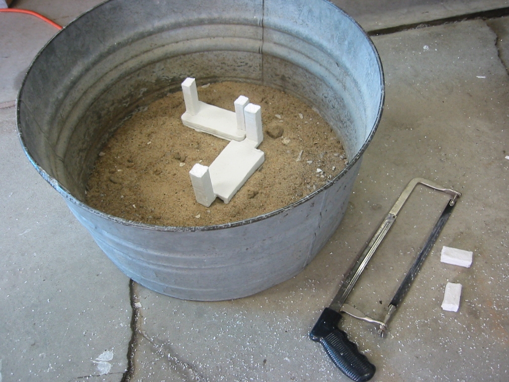 (5) Two test parts are set on a bed of sand with the pour spouts or