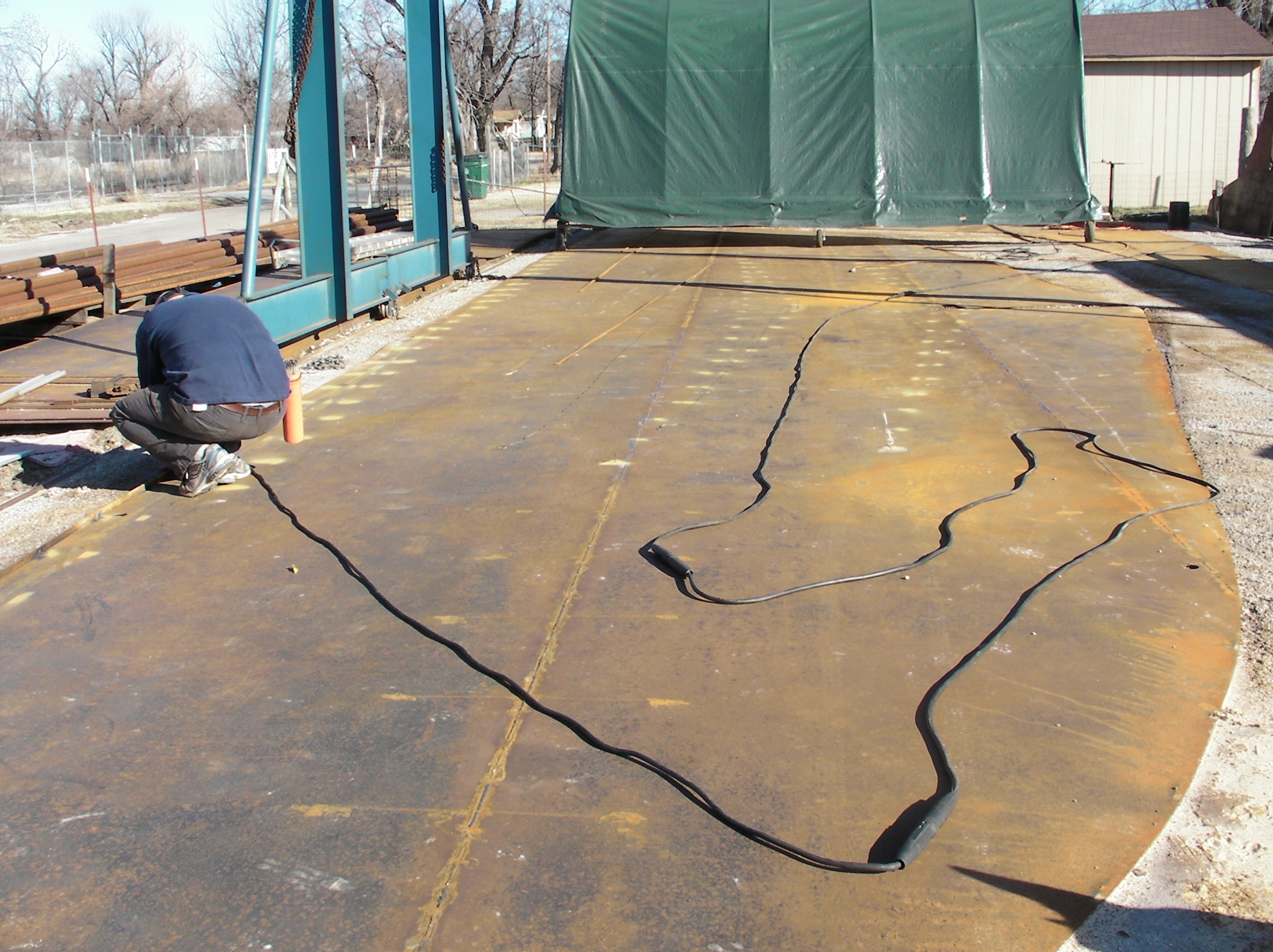 The ground cable should be attached close by, but anywhere on the steel works.