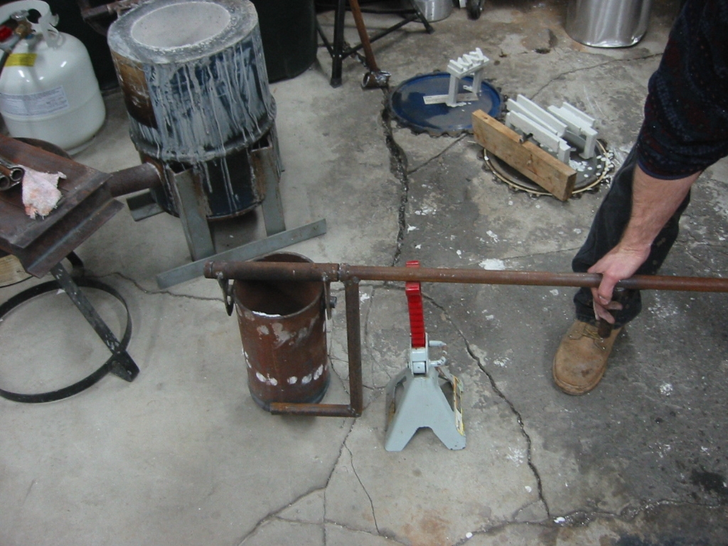 (15) Tilting arm that is welded to  the handle is rotated down to tilt the crucible for pouring.