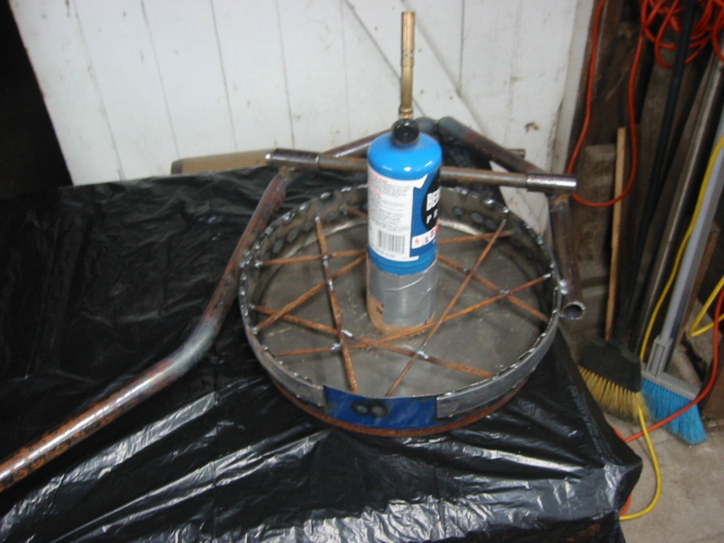 (2) Pipe frame welded to the top of the oil drum lid with rods to reinforce the Mizzou and a bottle to form the vent.