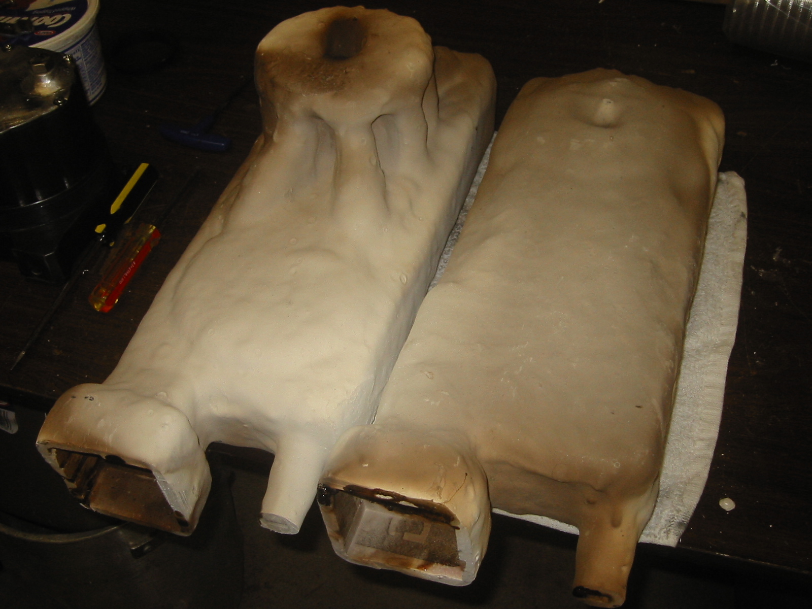 (7) Parts after they have be  fired in the foundry to harden the investment and burn off the  remains of the foam.