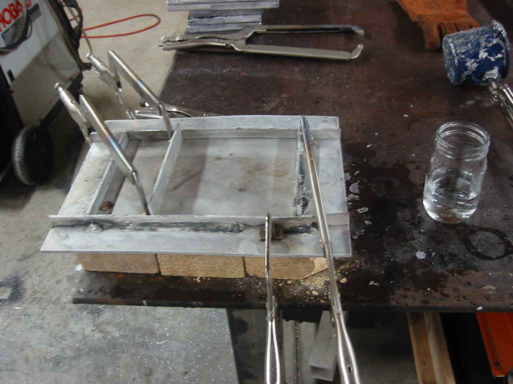 (1) Aluminum mold sitting on fire bricks and clamped down to the work table.